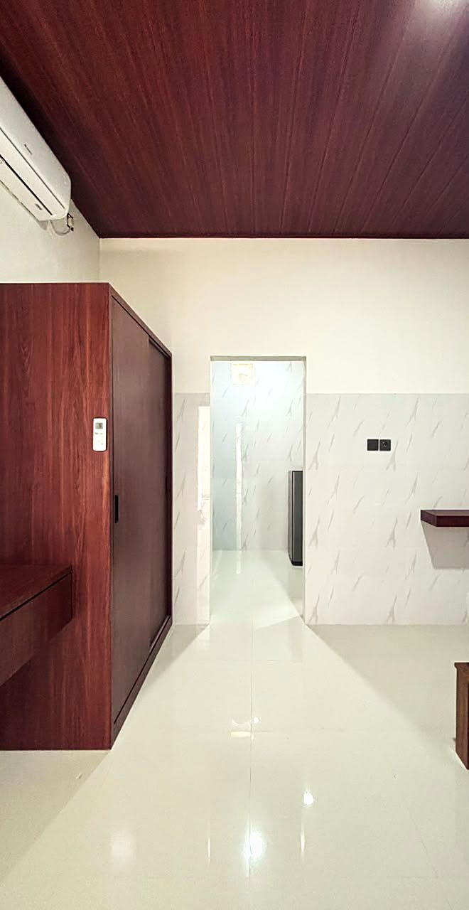 Interior kamar dengan lemari kayu dan akses kamar mandi dalam Yka Residence Jimbaran (foto asli)